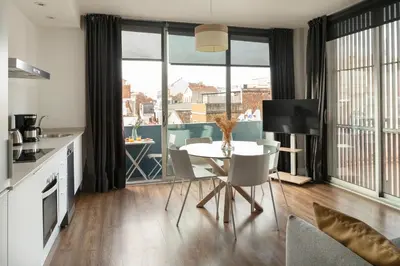 a kitchen and living room with a table and chairs at Feelathome Poblenou Beach Apartments in Barcelona