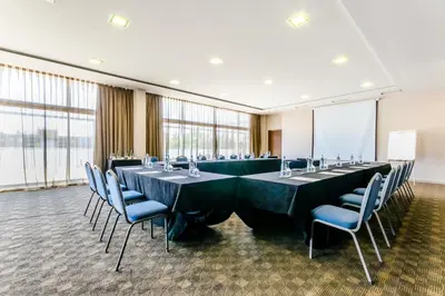 a conference room with long tables and blue chairs at Eurostars Executive in Barbera del Valles