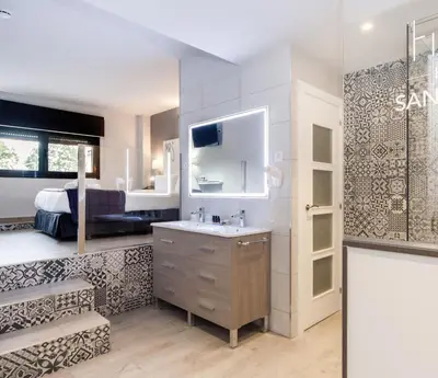 a bathroom with a sink and a bedroom at HOTEL SANT PERE ll HSPII in Rubí