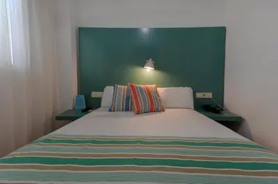 a bedroom with a large bed with two night stands at Yomo Hostal BCN Port in Barcelona