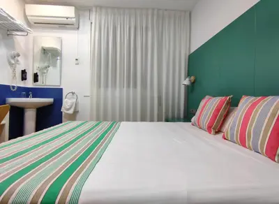 a bedroom with a large bed and a sink at Yomo Hostal BCN Port in Barcelona