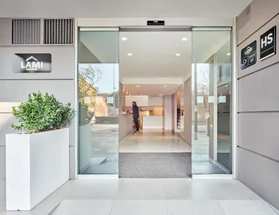 a man walking through a glass door of a building at Hostal Lami in Esplugues de Llobregat
