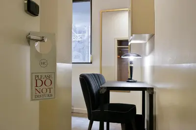 a room with a desk and a chair and a sign at Hotel El Call in Barcelona
