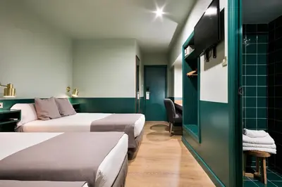 a hotel room with two beds and a tv at Hotel El Call in Barcelona