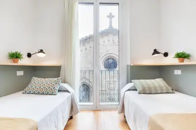 two beds in a room with a window at Hostal Fernando in Barcelona