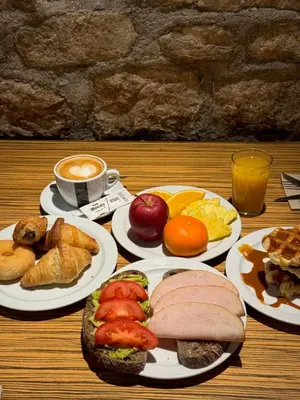 a table with plates of food and a cup of coffee at Hostal Fernando in Barcelona