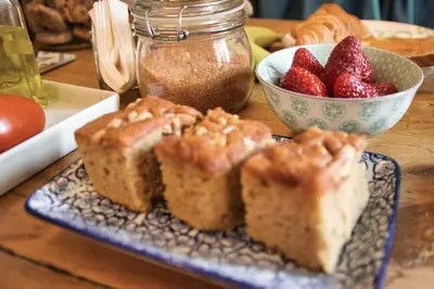 a table with a plate of bread and a bowl of strawberries at Factory Suites Barcelona in Barcelona
