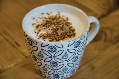 a blue and white cup of coffee with cocoa in it at Factory Suites Barcelona in Barcelona