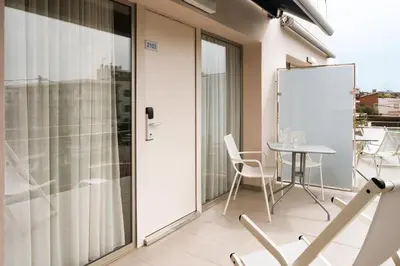 a room with a balcony with a table and chairs at Apartamentos Castellmar in Castelldefels