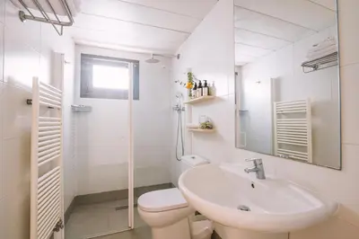 a bathroom with a sink and a toilet and a shower at Apartamentos Castellmar in Castelldefels