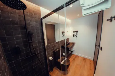 a bathroom with a shower with a sink and a mirror at Hotel Transit in Barcelona