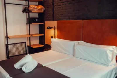 a bedroom with a bed with white sheets and pillows at Hotel Transit in Barcelona