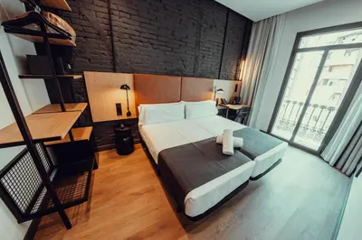 a bedroom with a large bed and a large window at Hotel Transit in Barcelona