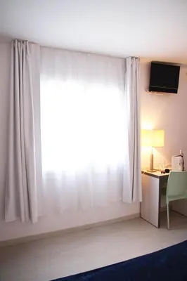 a room with a window and a desk with a computer at Parrots Sitges Hotel in Sitges