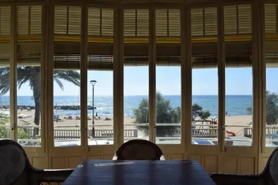 a dining room with a table and a view of the beach at Apartamentos Les Barbes in Caldes d'Estrac