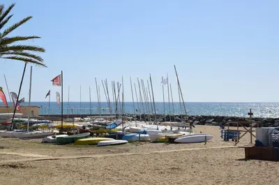 a bunch of boats are lined up on the beach at Apartamentos Les Barbes in Caldes d'Estrac