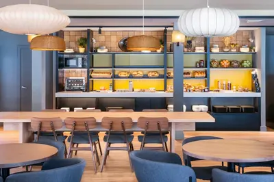 a restaurant with tables and chairs and a kitchen at B&B HOTEL Barcelona Mollet in Mollet del Vallès
