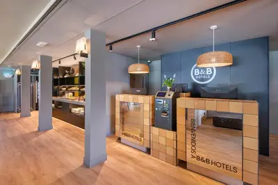 a coffee shop with blue walls and a counter at B&B HOTEL Barcelona Mollet in Mollet del Vallès