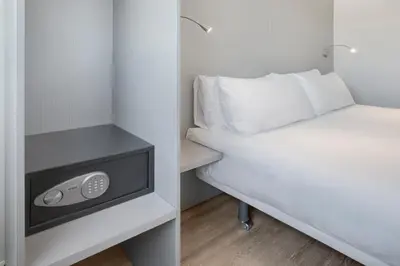 a small bedroom with a bed and a night stand at B&B HOTEL Barcelona Granollers in Les Franqueses del Vallès