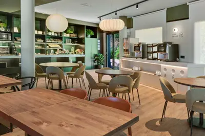 a restaurant with tables and chairs and a counter at B&B HOTEL Barcelona Granollers in Les Franqueses del Vallès