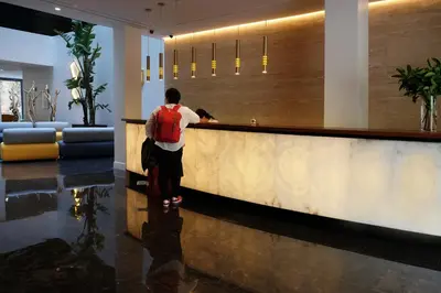 a man with a backpack standing at a counter in a lobby at Chi in Barcelona