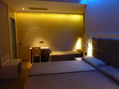 a bedroom with a bed and a table with a chair at Barcelona House in Barcelona