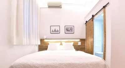 a bedroom with a white bed with white pillows at Hostal Girona in Barcelona