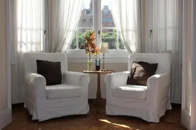 two white chairs in a room with a window at Ally's Bed&Breakfast, in Barcelona