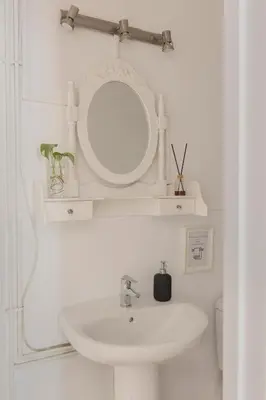a white bathroom with a sink and a mirror at Ally's Bed&Breakfast, in Barcelona