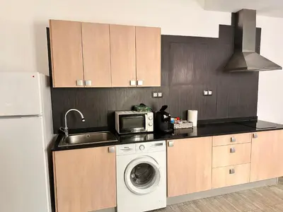a kitchen with a washing machine and a microwave at Apartaments IRI in Pineda de Mar