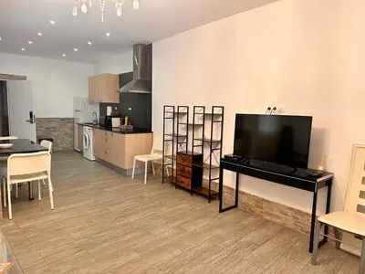 a living room with a flat screen tv and a table at Apartaments IRI in Pineda de Mar