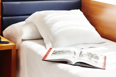 an open book sitting on a bed with a pillow at Barcelona Century Hotel in Barcelona