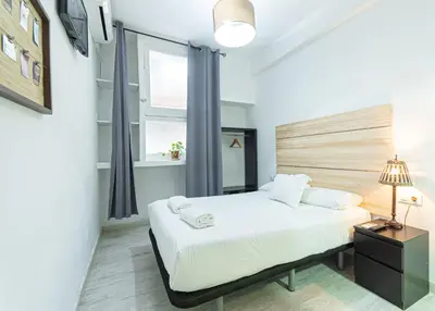 a bedroom with a bed with white sheets and a window at Easy Sants by Bossh! Hotels in Barcelona