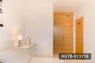 a bedroom with a bed and a wooden door at Blanco Vinyet in Sitges