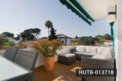 a patio with a couch and chairs on a balcony at Blanco Vinyet in Sitges