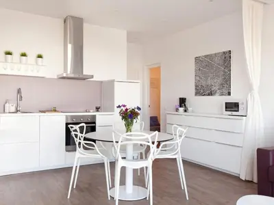 a kitchen with white cabinets and a table and chairs at Stay U-nique Apartments Sant Pau in Barcelona