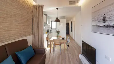 a living room with a couch and a dining room at Hotel Sagrada Familia Apartments in Barcelona