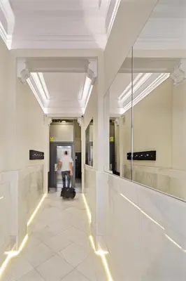 a person walking down a hallway in a building at Hotel Sagrada Familia Apartments in Barcelona