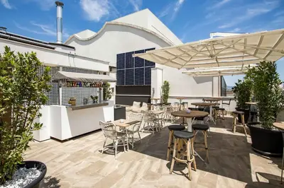 a restaurant with a table and chairs and a chef in the kitchen at Room Mate Anna, Barcelona in Barcelona