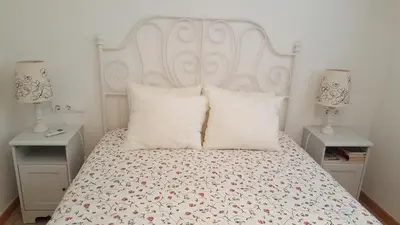 a bedroom with a white bed with two night stands at Apartamento Hector en Sitges in Sitges