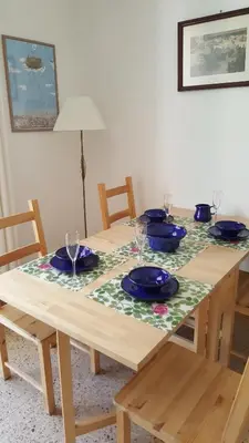 a wooden table with blue plates and glasses on it at Apartamento Hector en Sitges in Sitges