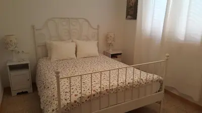 a bedroom with a white bed with a white headboard at Apartamento Hector en Sitges in Sitges