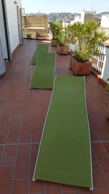 a row of green yoga mats on a roof at The Sky Attic Apartment in Sitges