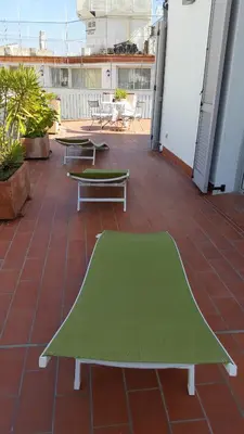 a green table on a patio with tables at The Sky Attic Apartment in Sitges