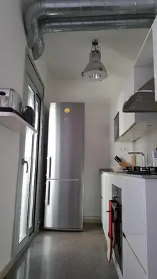 a kitchen with a stainless steel refrigerator in a room at The Sky Attic Apartment in Sitges