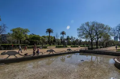 people walking around a fountain in a park at Super central 3BR apartment, spacious and bright in Barcelona