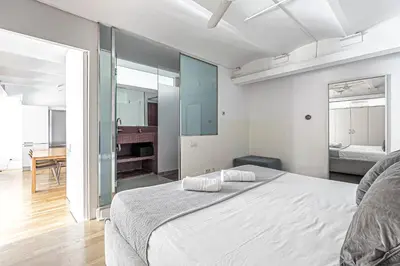 a bedroom with a large white bed and a dining room at Super central 3BR apartment, spacious and bright in Barcelona