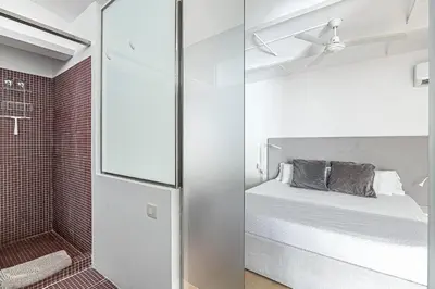 a small bedroom with a bed and a shower at Super central 3BR apartment, spacious and bright in Barcelona
