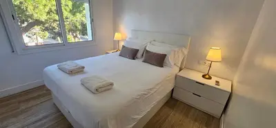 a bedroom with a white bed with two towels on it at Castelldefels Playa in Castelldefels