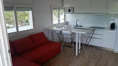 a kitchen with a red couch and a kitchen table at Castelldefels Playa in Castelldefels